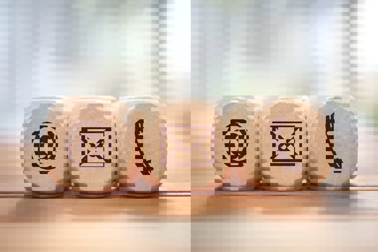 A picture of 3 dice with @, an envelope and a telephone symbol