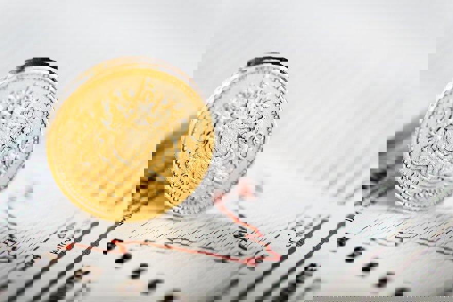 Pound coin over a graph going up and down