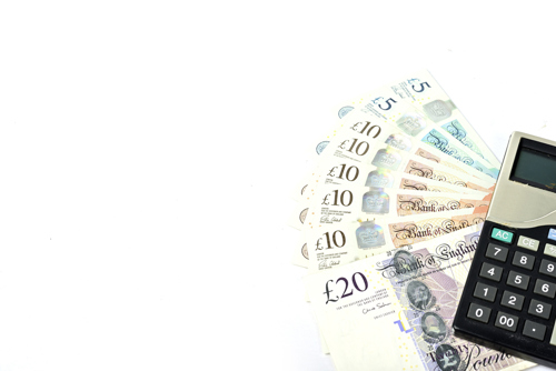 A picture of a calculator sitting over a set of £20 notes