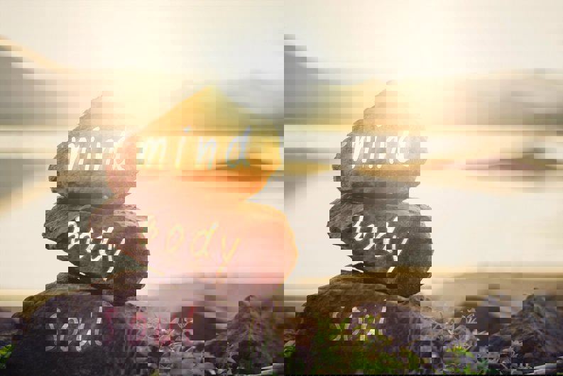 Three rocks on top of each other with mind, body, soul written on each